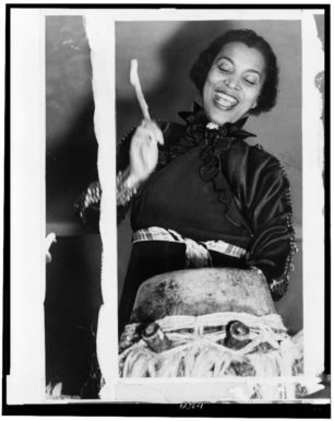 Zora Neale Hurston Beating a Haitian Maman drum, 1937.